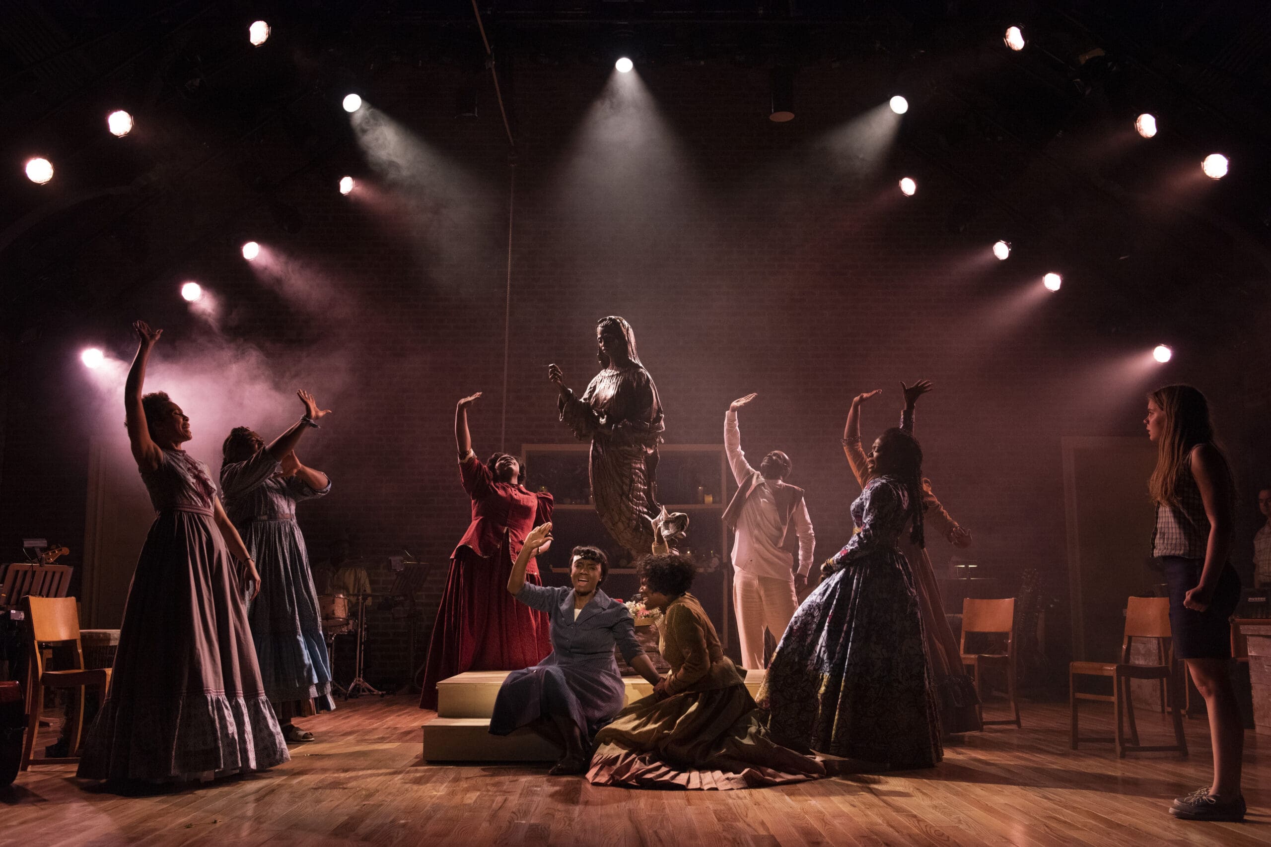 Theater performance with actors in period costumes under spotlights, evoking drama and storytelling.