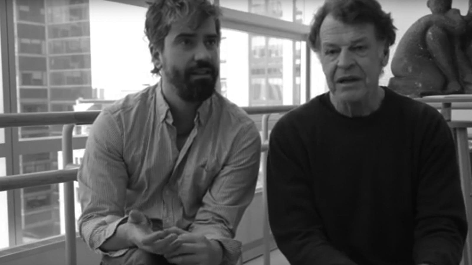 Black and white photo of two men discussing art, possibly for posterity.