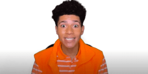 Happy young actor in orange vest, ready for kids' play about racism.