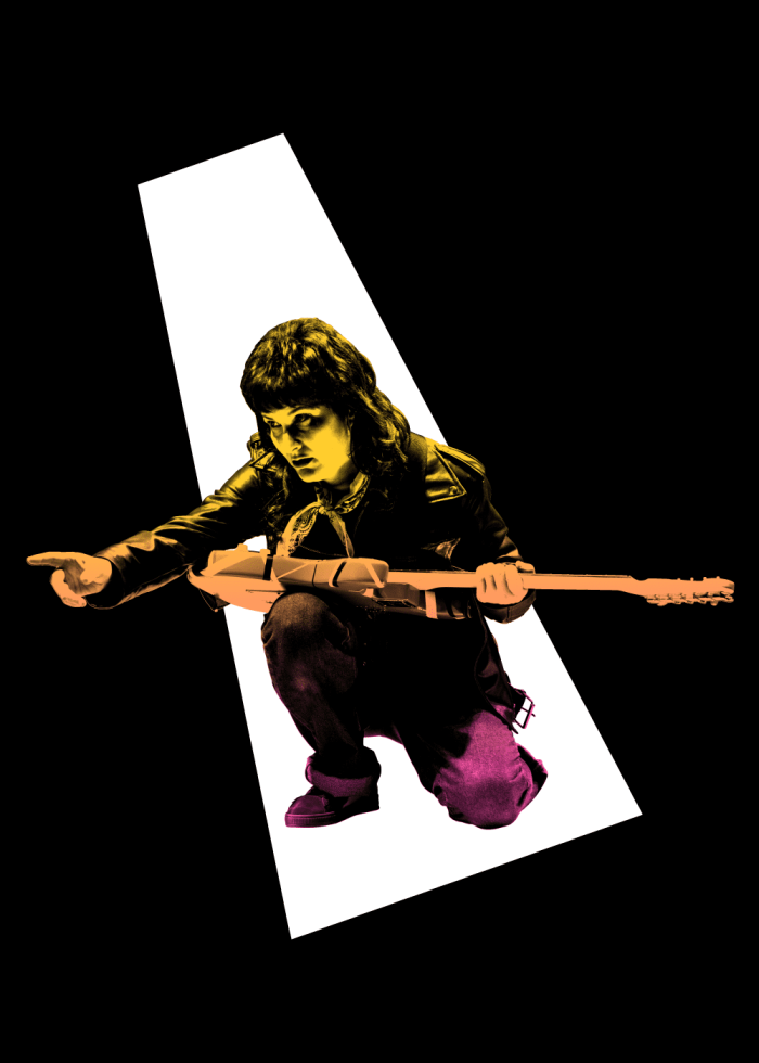 A female rock musician kneels, playing an electric guitar.