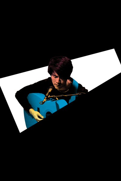 Young man playing a blue acoustic guitar