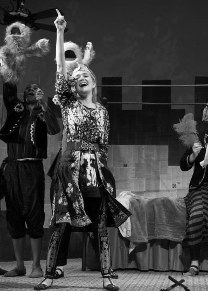 Cast of '1001 Nights' performance on stage, featuring actors with puppets and costumes.