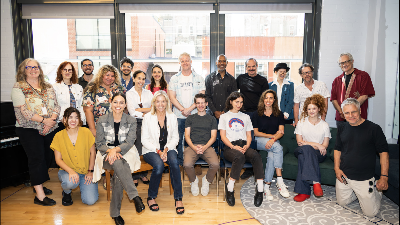Large group of theatre professionals posing for a photo