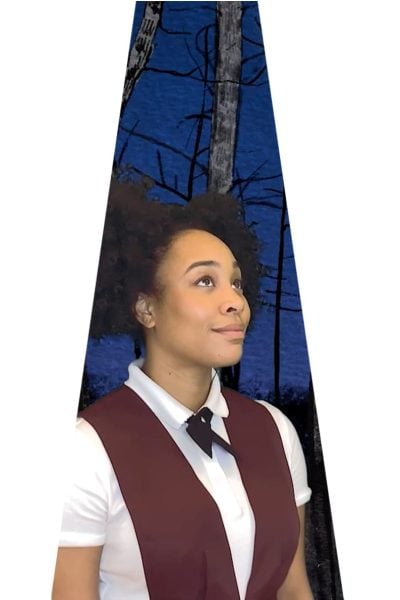 Young woman in maroon vest and white shirt, looking up thoughtfully against a dark blue forest background. "She Persisted" musical.