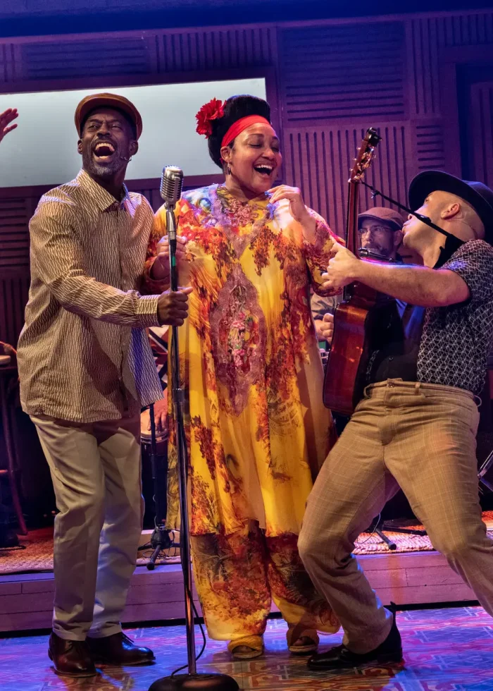 Cast of 'Buena Vista Social Club' singing and playing instruments on stage.