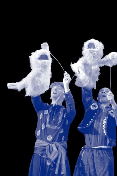 Three puppeteers operate fluffy puppets during a theatrical performance of 1001 Nights.