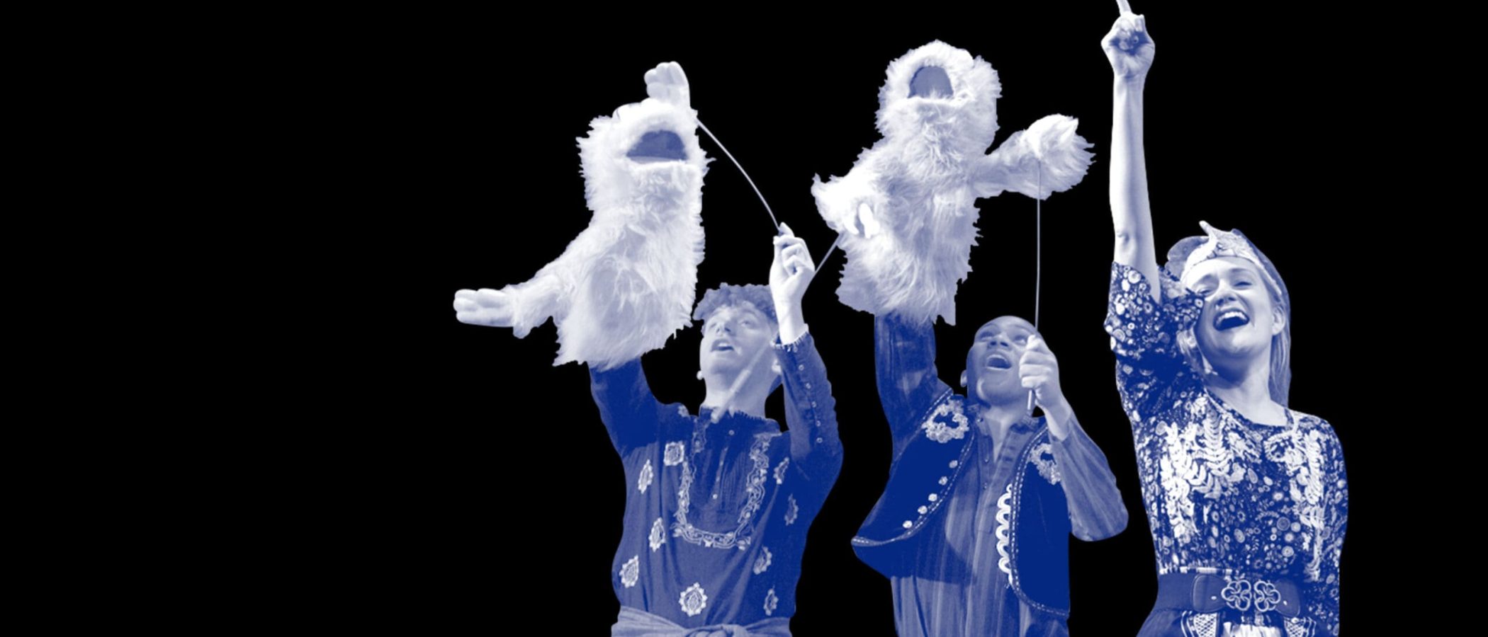 Three puppeteers operate fluffy puppets during a theatrical performance of 1001 Nights.