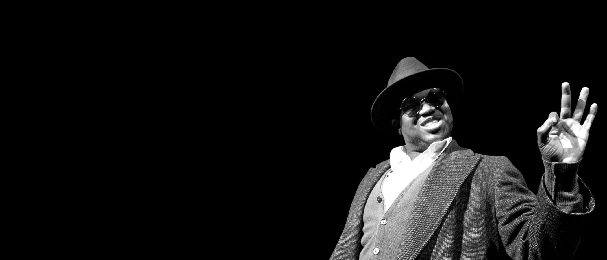 Mr. Chickee, wearing a hat and sunglasses, gives an "OK" sign.