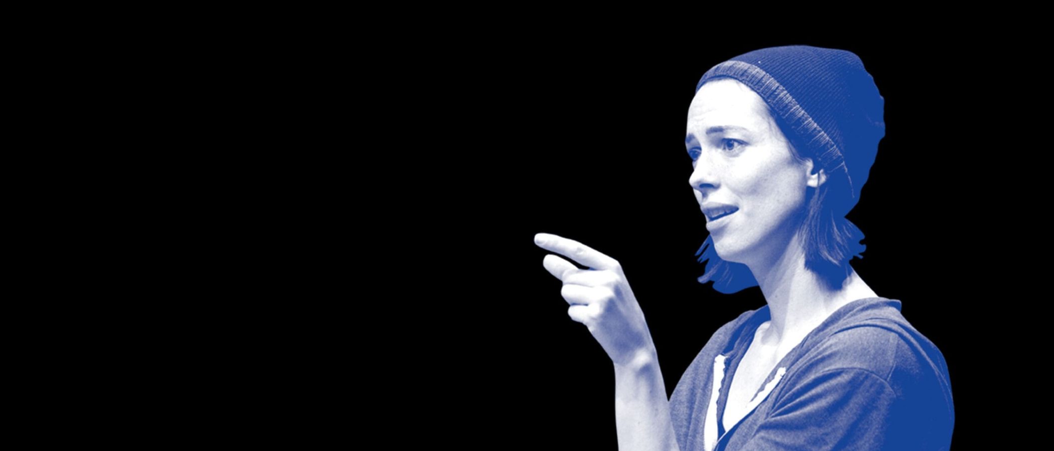 Woman in beanie pointing, profile view
