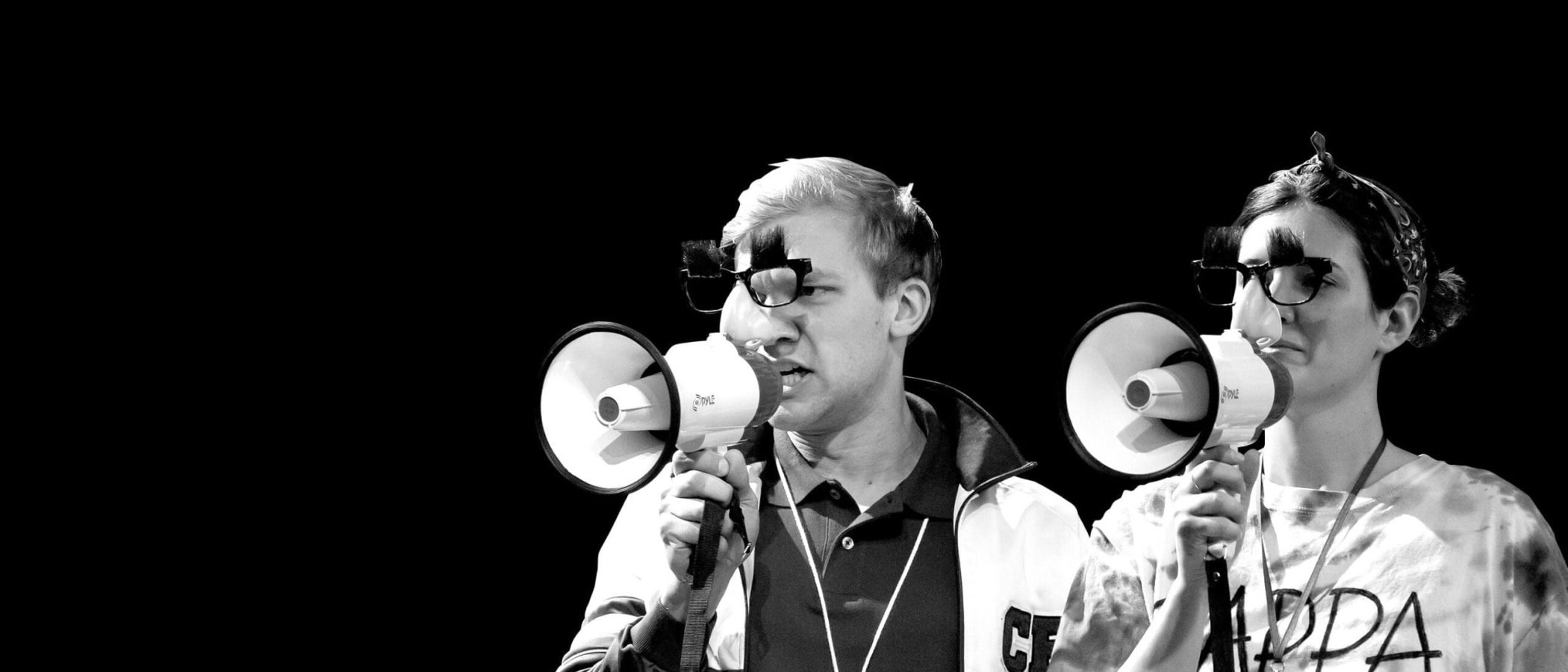Two counselors at Camp Kappawanna, wearing novelty glasses and holding megaphones.