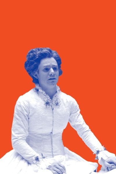 Two women in period costumes, one in a white dress, the other in a maid's uniform, sit together.