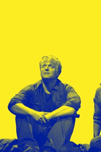 A man and woman sit on the shore, gazing out at the wide world.