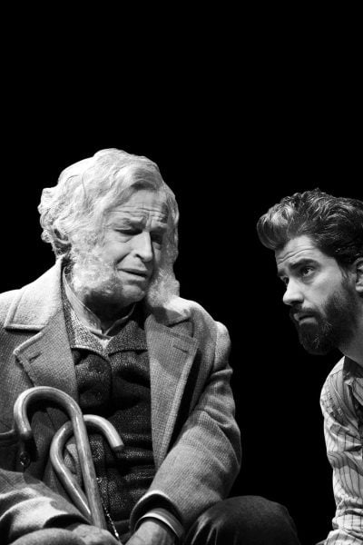 Black and white photo of two men, one elderly, one younger, in conversation. A scene of legacy and posterity.