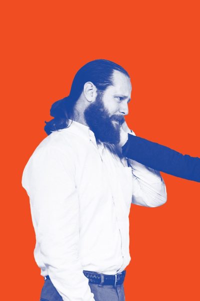 A man and woman face each other; the woman's hand is on the man's beard.