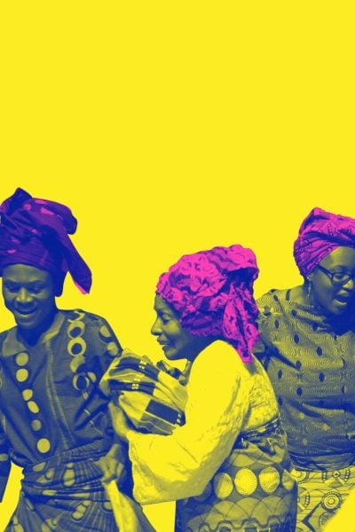 Four women in vibrant head wraps and patterned dresses joyfully celebrate.