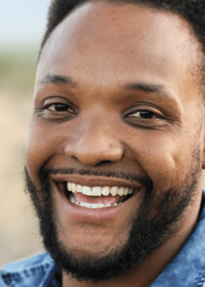 Smiling man with a beard in a denim shirt