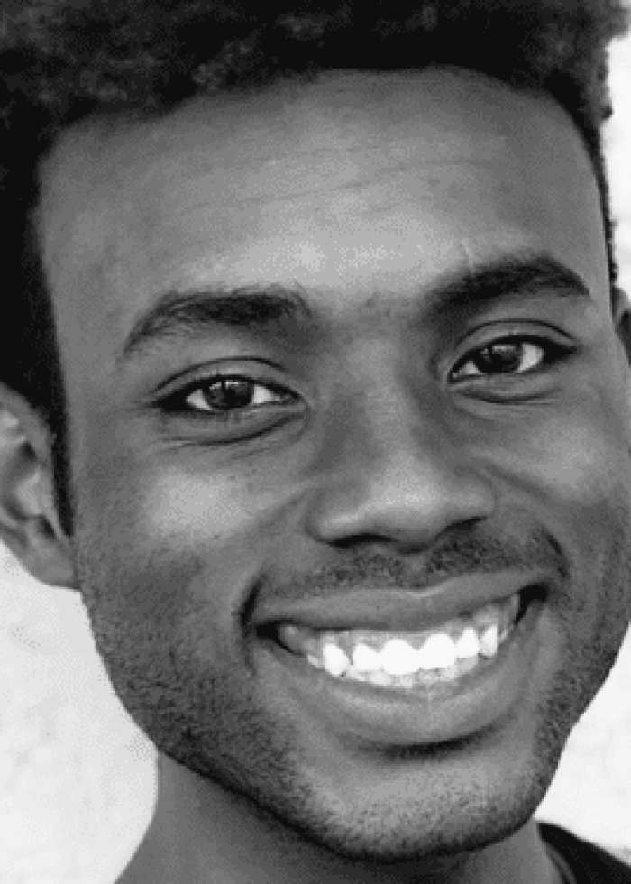 Smiling young Black man with short, curly hair