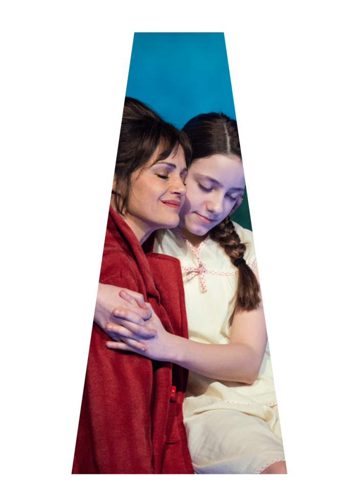 A mother and daughter embrace, eyes closed, conveying comfort and love.