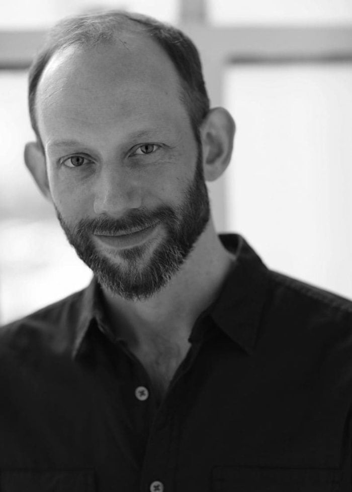 Andy Schneeflock, a man with a beard, looking at the camera, posing for a portrait.