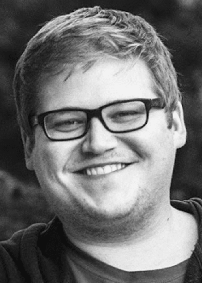 Adam Roebling smiling, wearing glasses