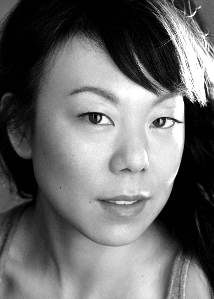 Close-up black and white portrait of Ali Ahn, looking directly at the camera.