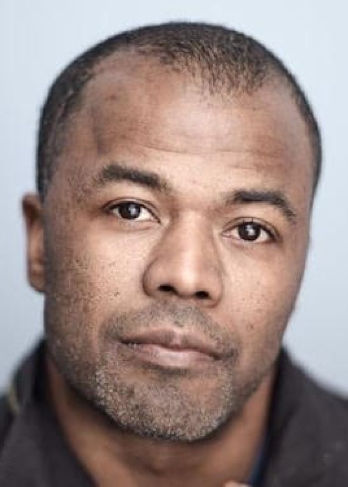 Portrait of Akin Salawu, a Black man with short hair and a beard, looking at the camera.