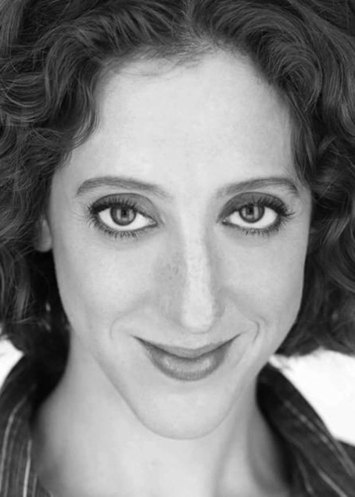 Alison Cimmet smiling, looking directly at the camera in a black and white headshot.