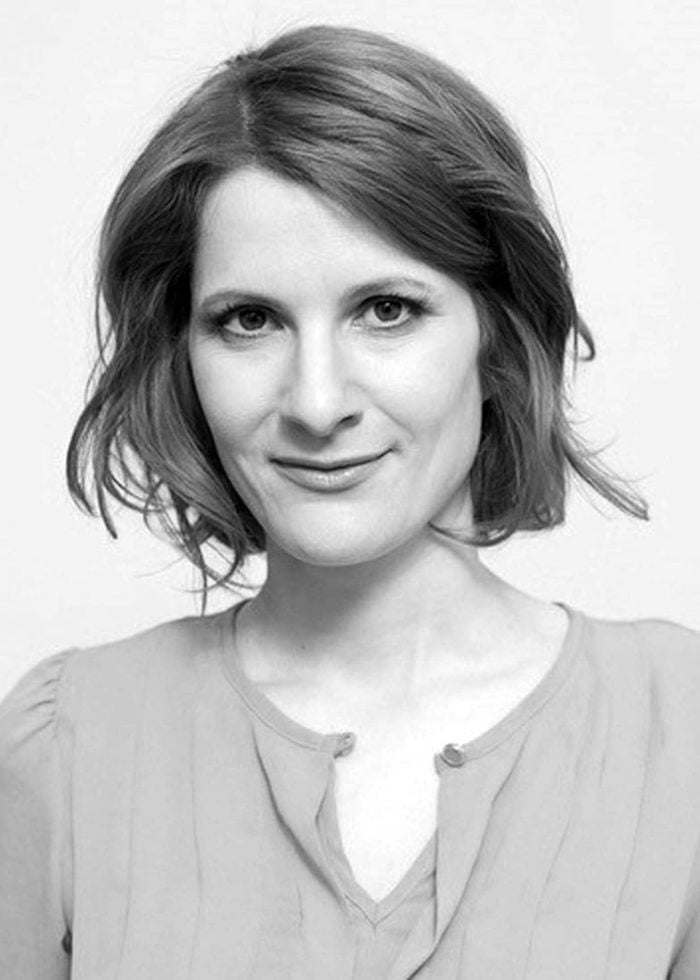 Amy Staats smiling, looking at the camera in a studio setting.