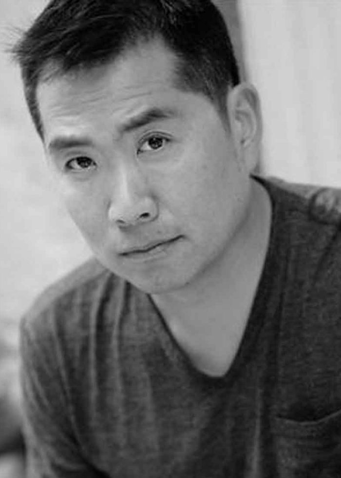 Andrew Pang, portrait in grayscale, looking directly at the camera