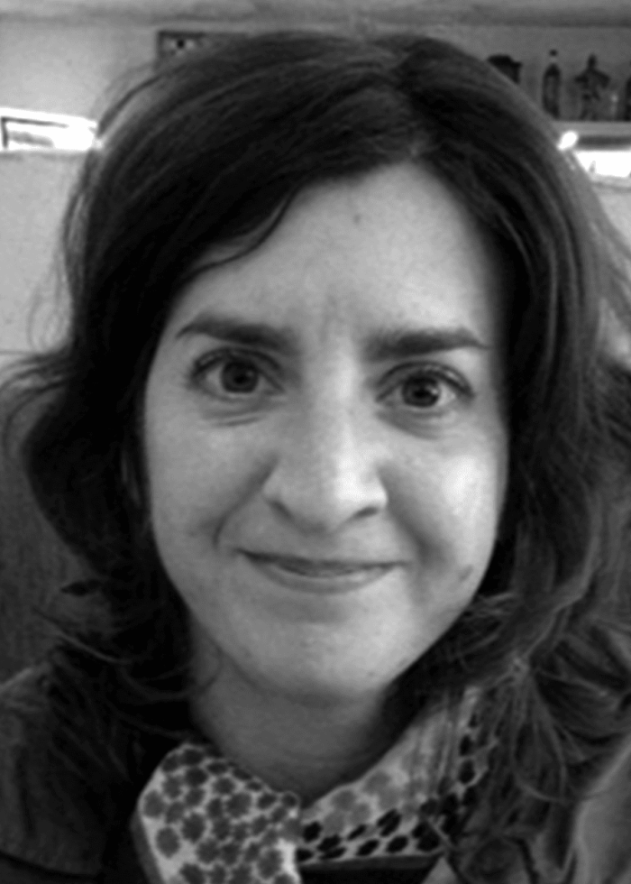 Anya Saffir, smiling, looking at the camera, wearing a patterned scarf.