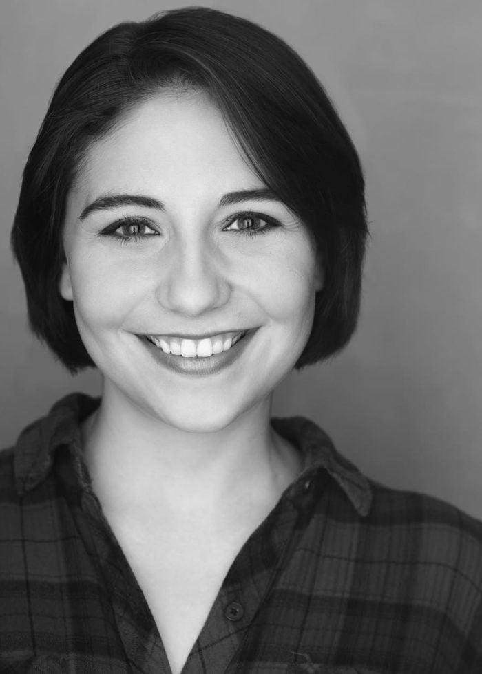Arielle Gonzalez smiling headshot, wearing a plaid shirt.