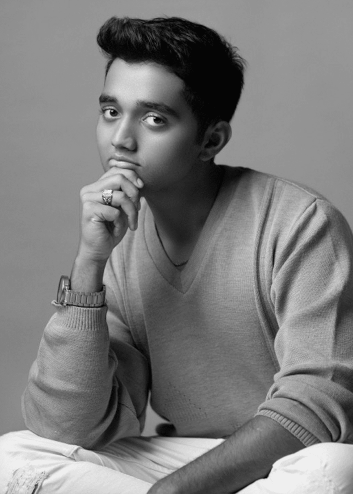 Arjun Athalye looking thoughtful, wearing a sweater and watch.