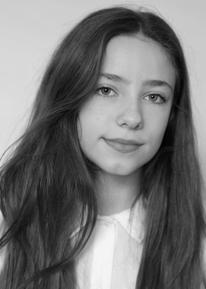 Portrait of Ava Briglia, a young woman with long hair, looking at the camera