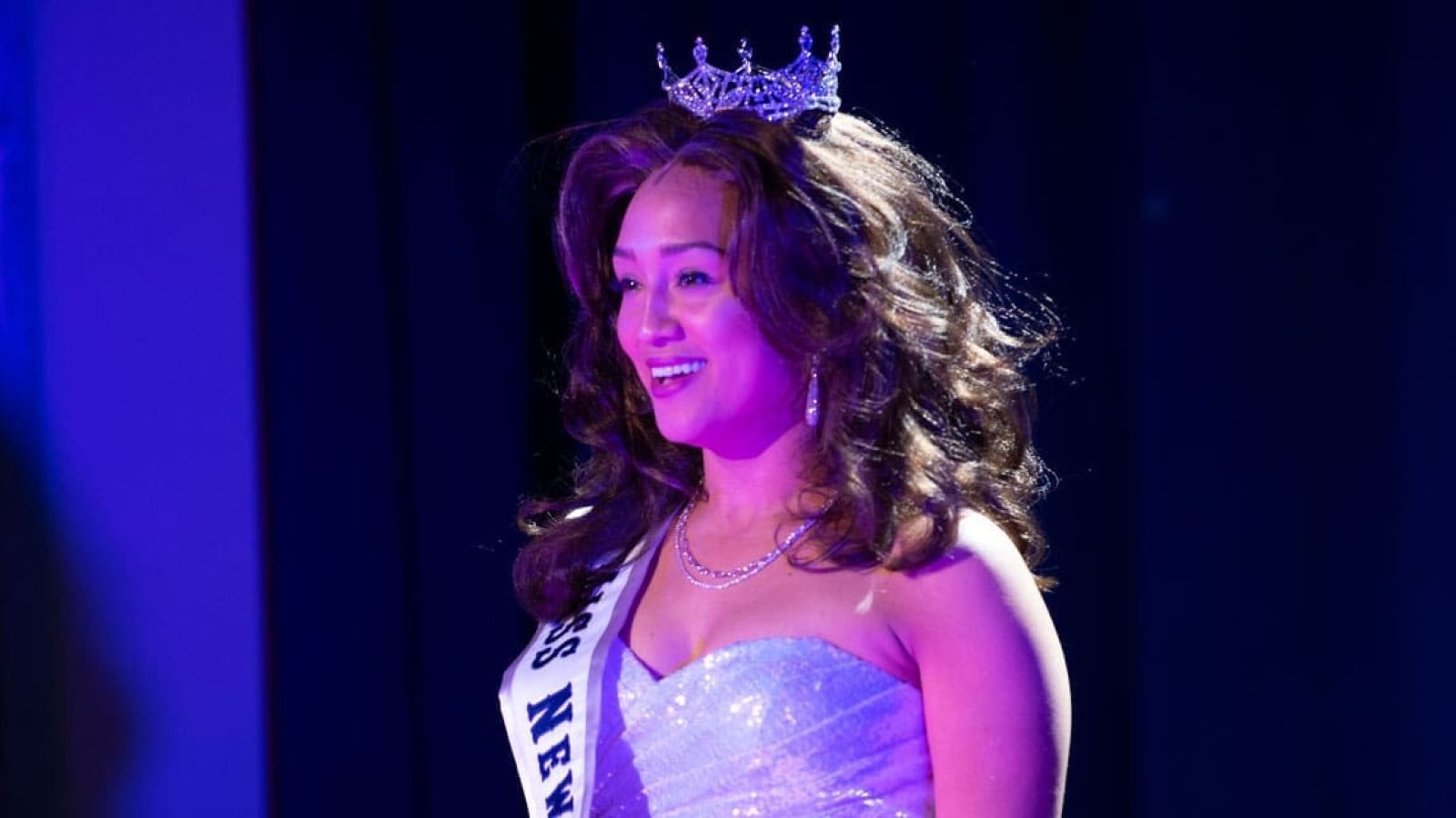Smiling Miss New Mexico in a sparkling gown and crown