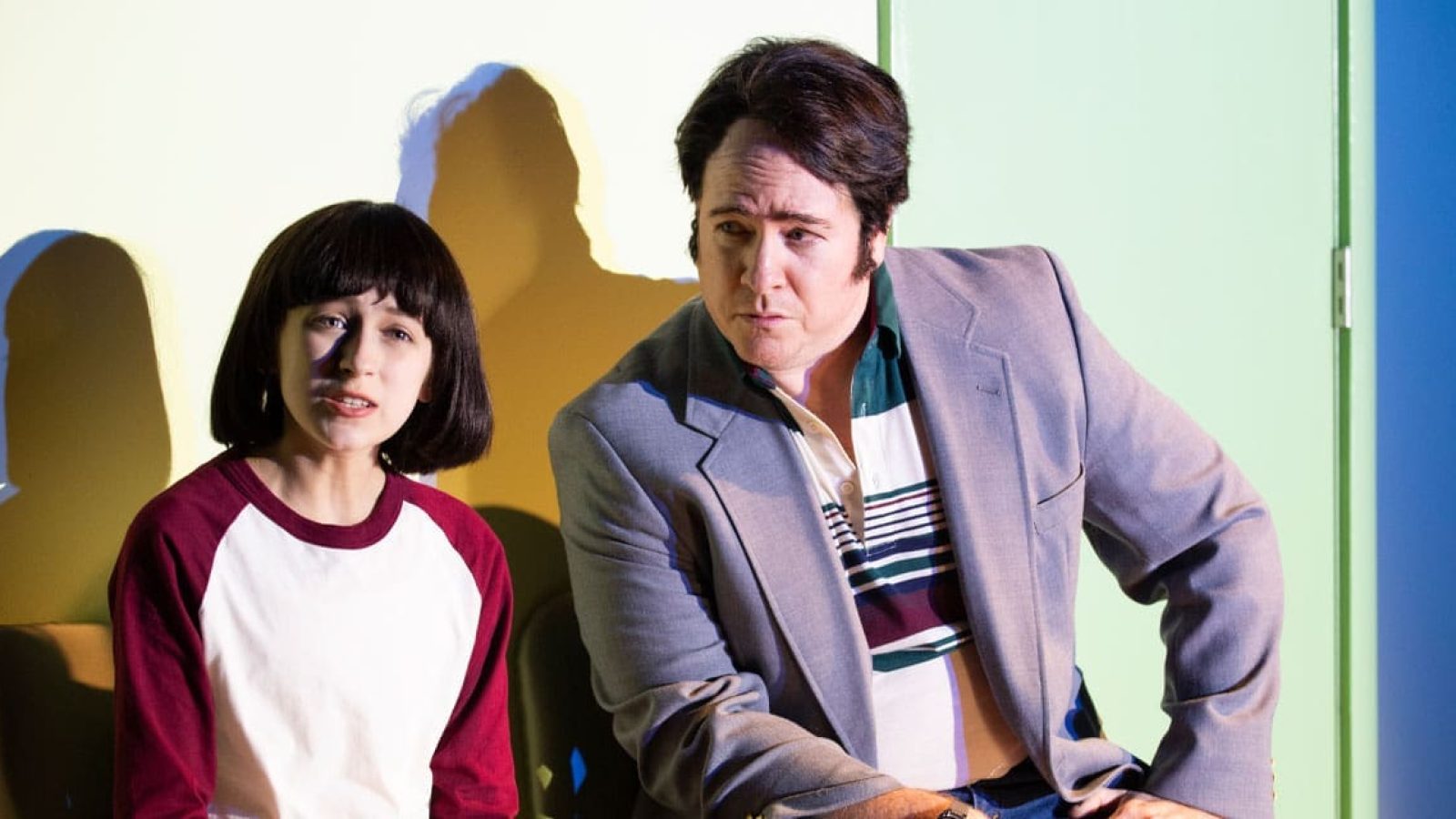 A man and young girl sit, possibly in a scene from the play "The Bedwetter.