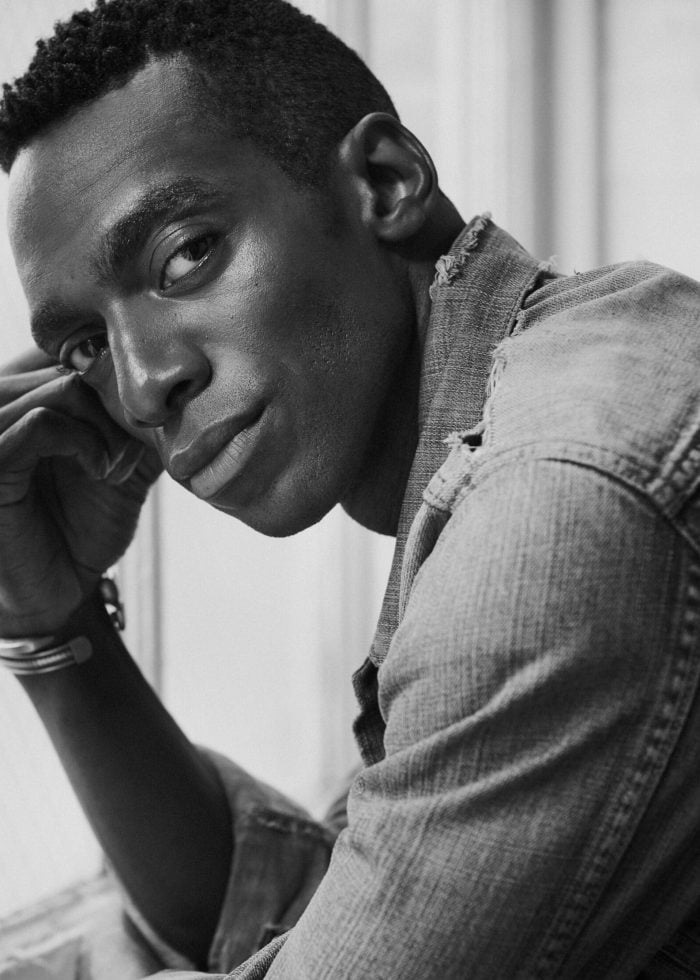 Daniel J. Watts in a black and white portrait, wearing a denim jacket.