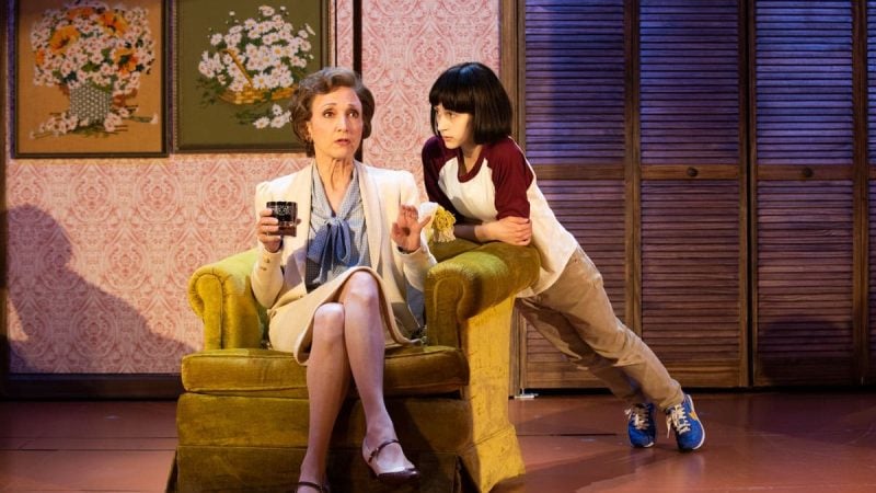 Sarah Silverman's "The Bedwetter" on stage: Actress seated with young actor leaning on chair.