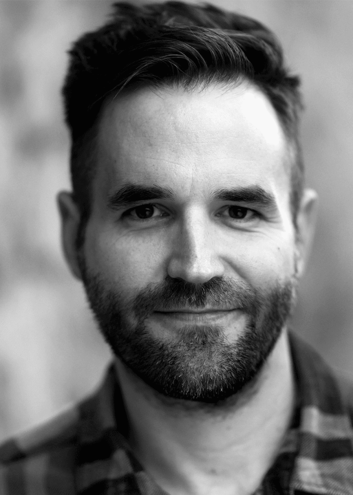 Close-up portrait of Connor Barrett with a beard and smiling