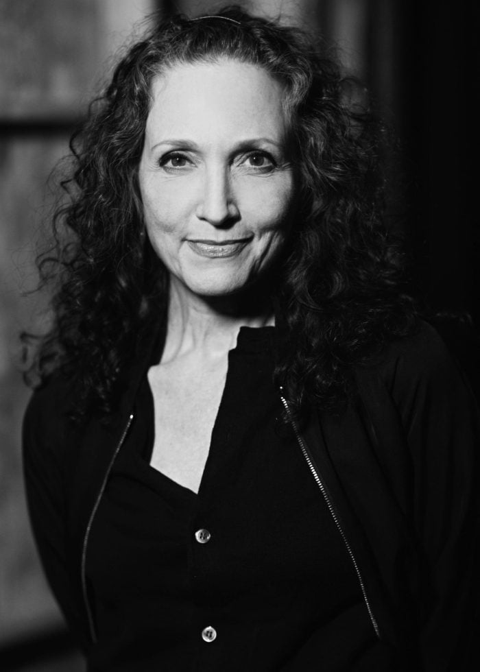 Bebe Neuwirth in a black and white portrait, smiling