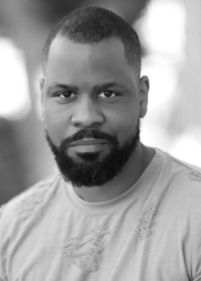 Bechir Sylvain, a man with a well-groomed beard, looks directly at the camera.