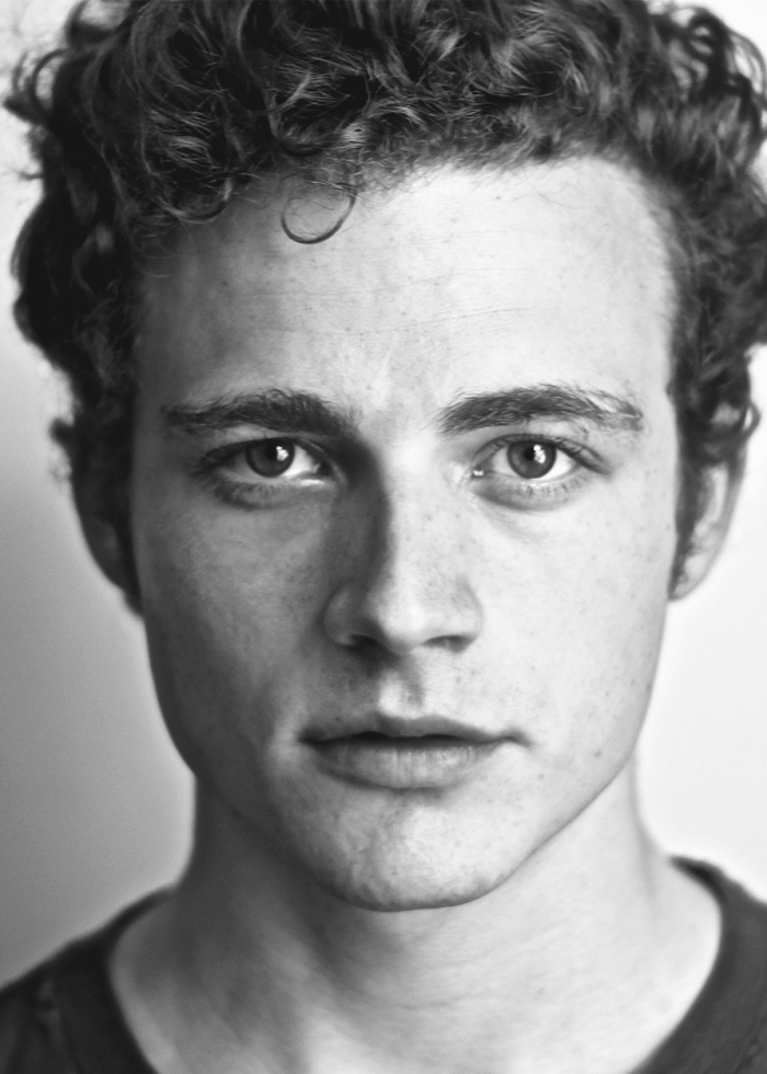 Ben-Rosenfield-Headshot Black and white portrait of actor Ben Rosenfield, looking directly at the camera.