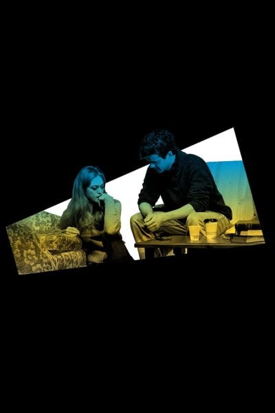 Man and woman in somber conversation, seated on a couch.