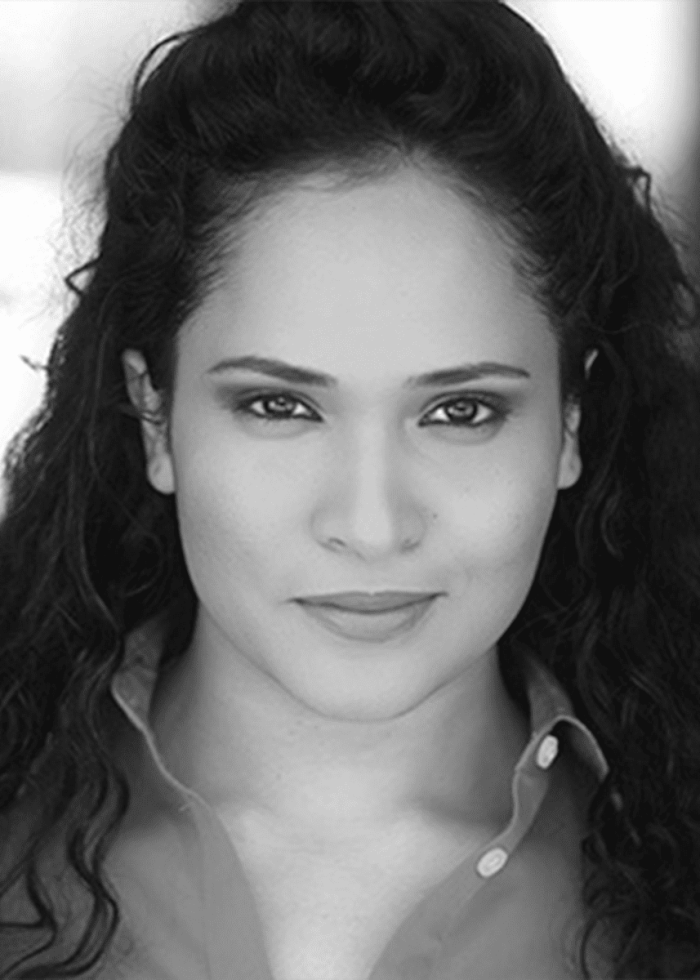 Portrait of Nilanjana Bose, with dark curly hair, looking directly at the camera