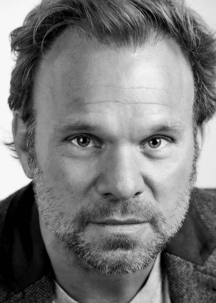 Close-up portrait of Norbert Leo Butz, looking directly at the camera.