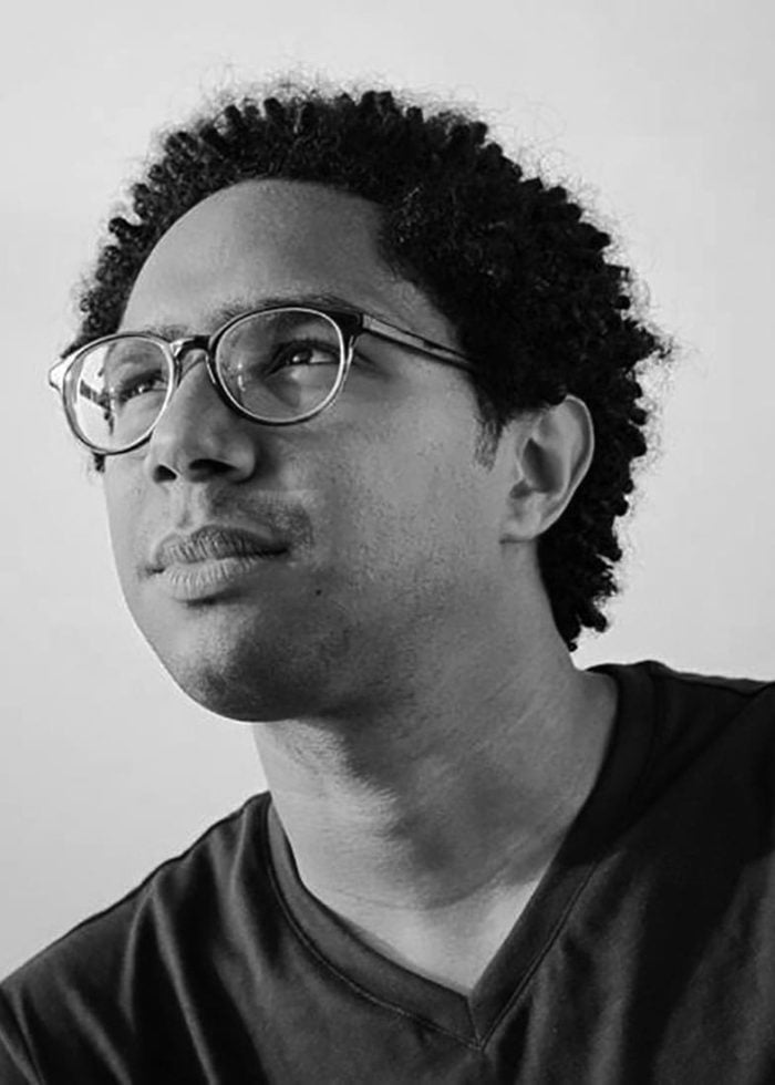 Christopher O'Neal looking up, wearing glasses and a dark shirt.
