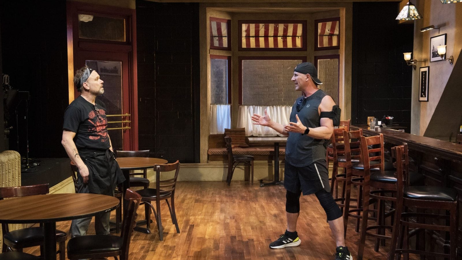 Two men converse in a Cornelia Street bar setting.