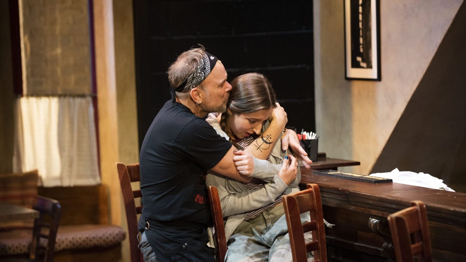 A man comforts a woman at a Cornelia Street bar.