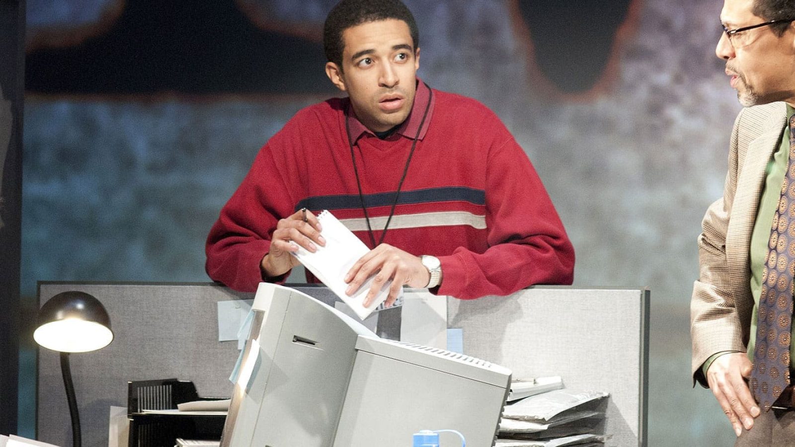 Three men in a busy office setting, discussing work. One man holds papers, reflecting a CQ/CX process.