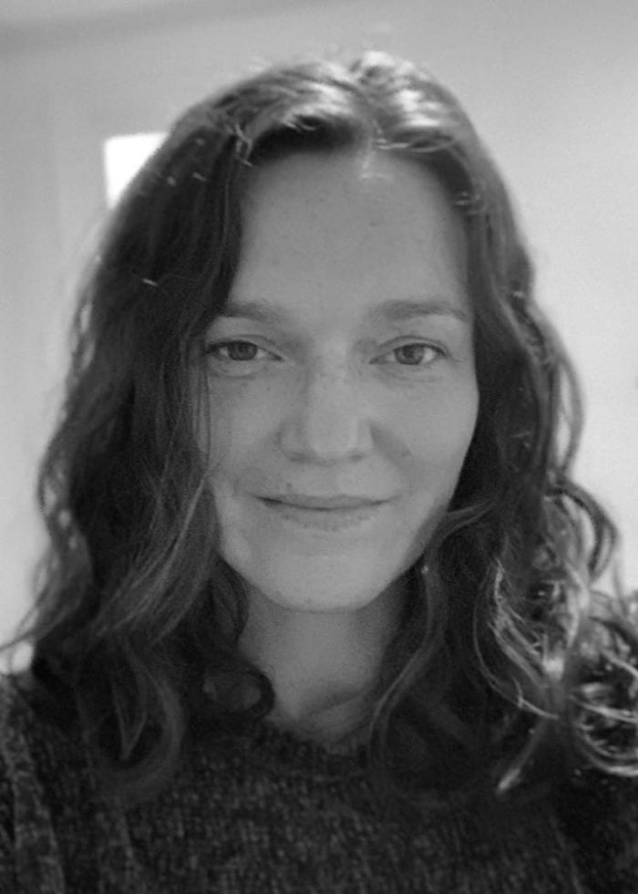 Portrait of Caitlin Ryan O'Connell, smiling with long wavy hair.