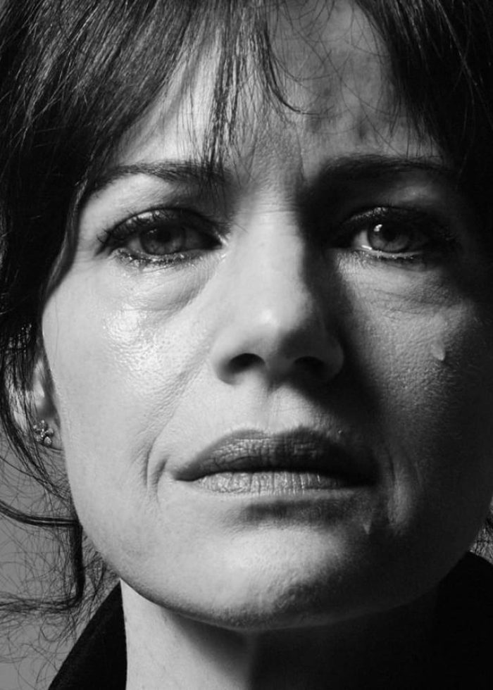 Carla Gugino looking emotional, close-up, in black and white.